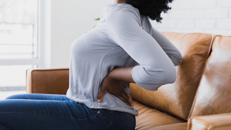 Mujer quejándose de dolor de espalda